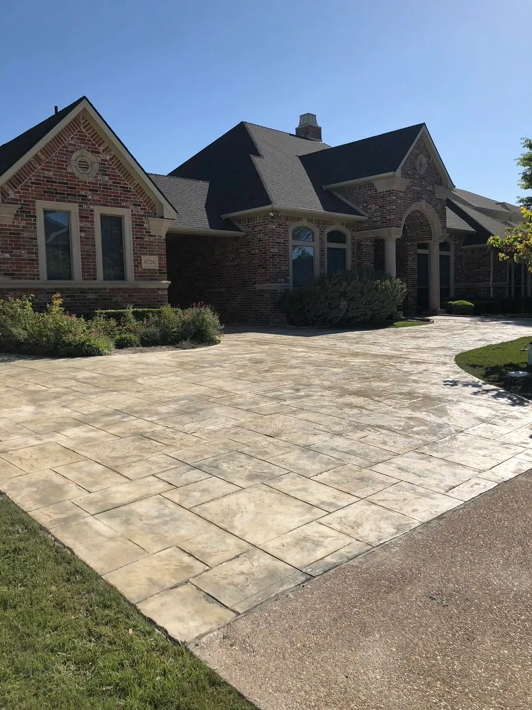 Stamped concrete driveway and entry court in an ashlar slate pattern in front of a two-storey brick home