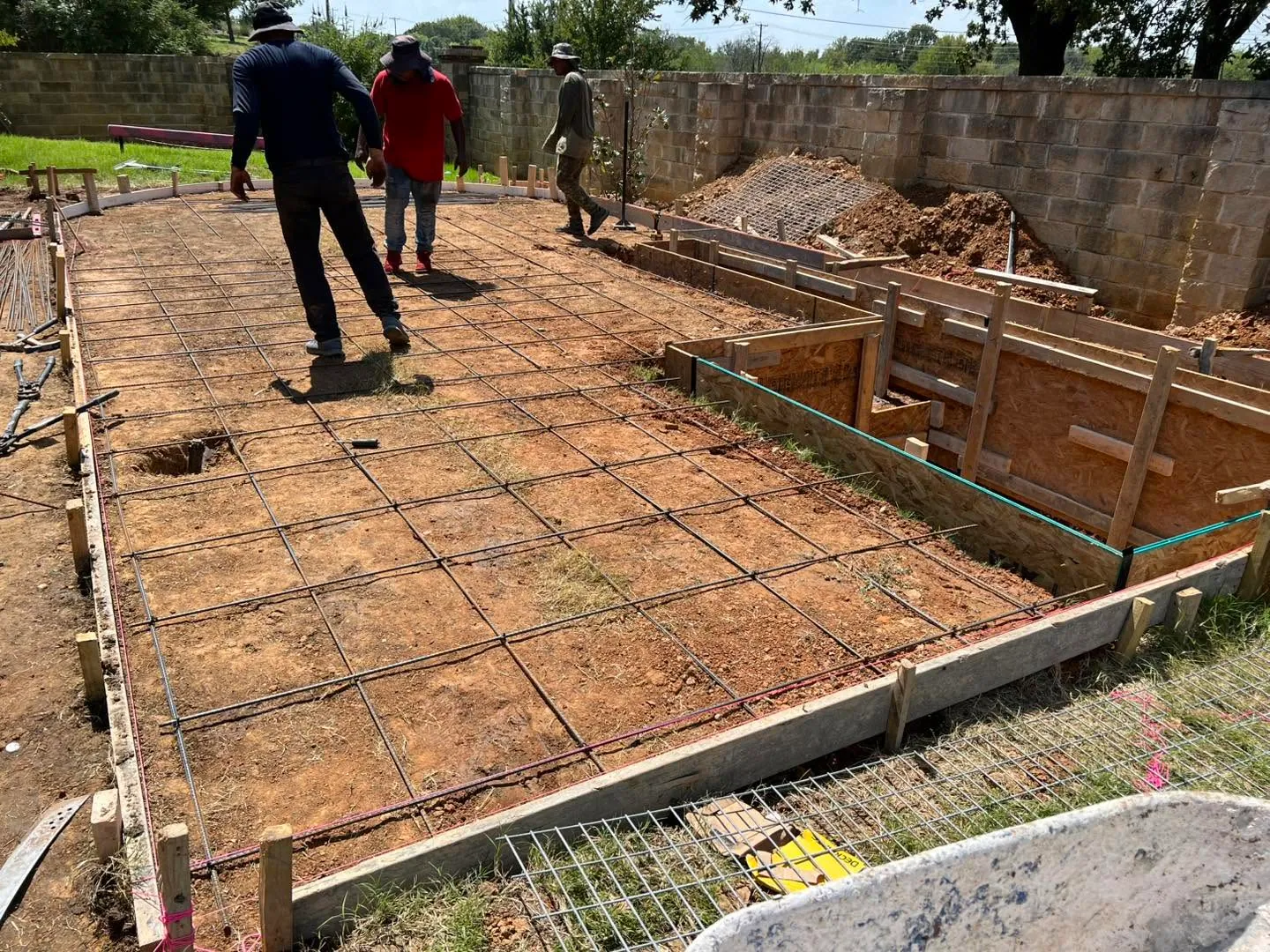 AV Fence & Concrete crew setting forms and tying rebar across a large slab before the pour